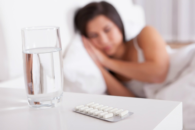 睡眠薬を飲む女性